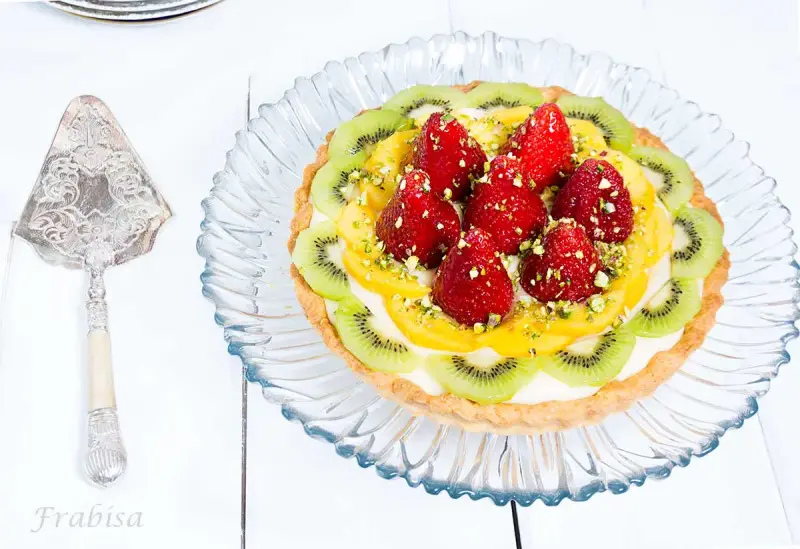 Tarta de frutas con fresas, kiwi y mango, decorada con pistachos. ¡Una delicia visual y gustativa!